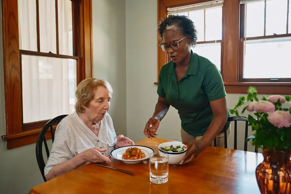 Care Pro serving nutritious meal to senior woman at home in Toronto East