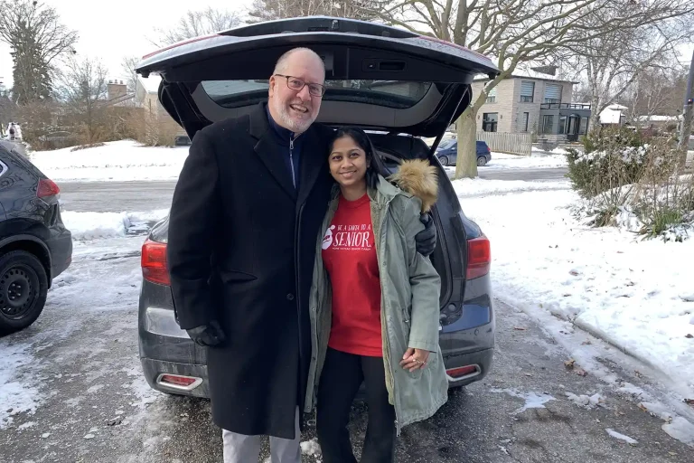 Two of the team members of Home Instead Toronto East delivering gifts for the Be A Santa To A Senior program