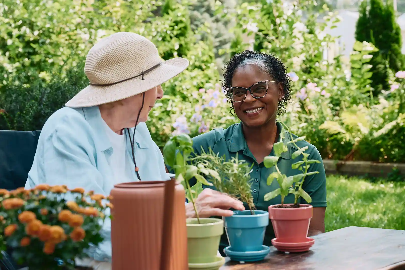 Care Pro helping senior woman with container gardening and planting herbs in Toronto backyard